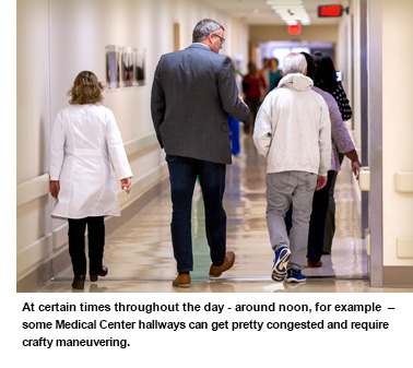 Crowded Hallway, woman walks round two individuals that are talking