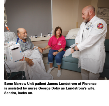Bone Marrow Unit patient James Lundstrom of Florence is assisted by nurse George Doby as Lundstrom's wife, Sandra, looks on.
