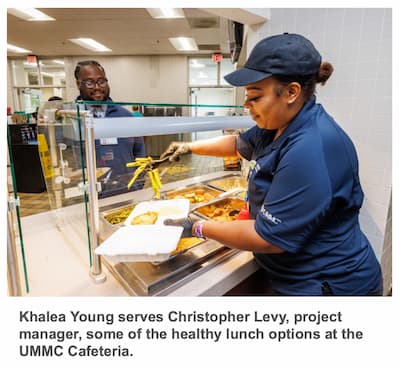 Khalea Young serves Christopher Levy, project manager, some of the healthy lunch options at the UMMC Cafeteria.