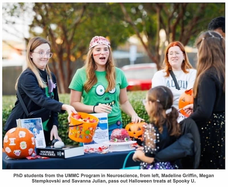PhD students from the UMMC Program in Neuroscience, from left, Madeline Griffin, Megan Stempkovski and Savanna Julian, pass out Halloween treats at Spooky U. Joe Ellis/ UMMC Communications