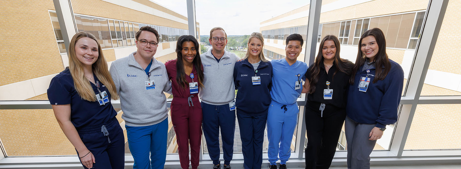 Group of eight UMMC-based pharmacy resident pose for a photo.