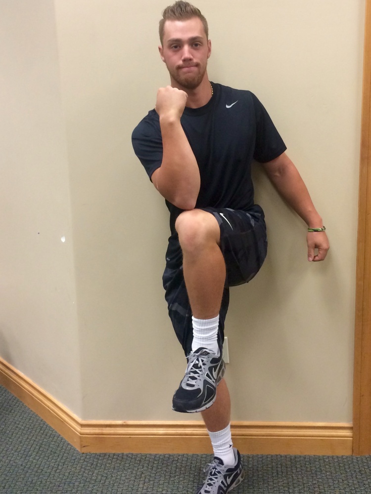 Man performing dynamic elbow to kneeexercise. 
