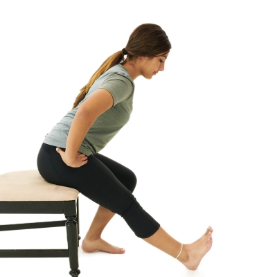 Woman doing seated hamstring stretch exercise.