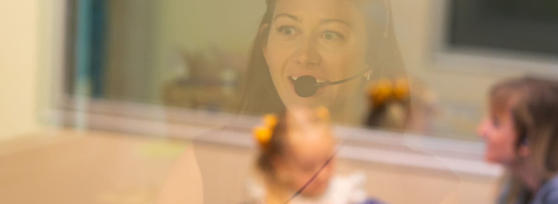 A professional smiles at a parent and child interacting together.