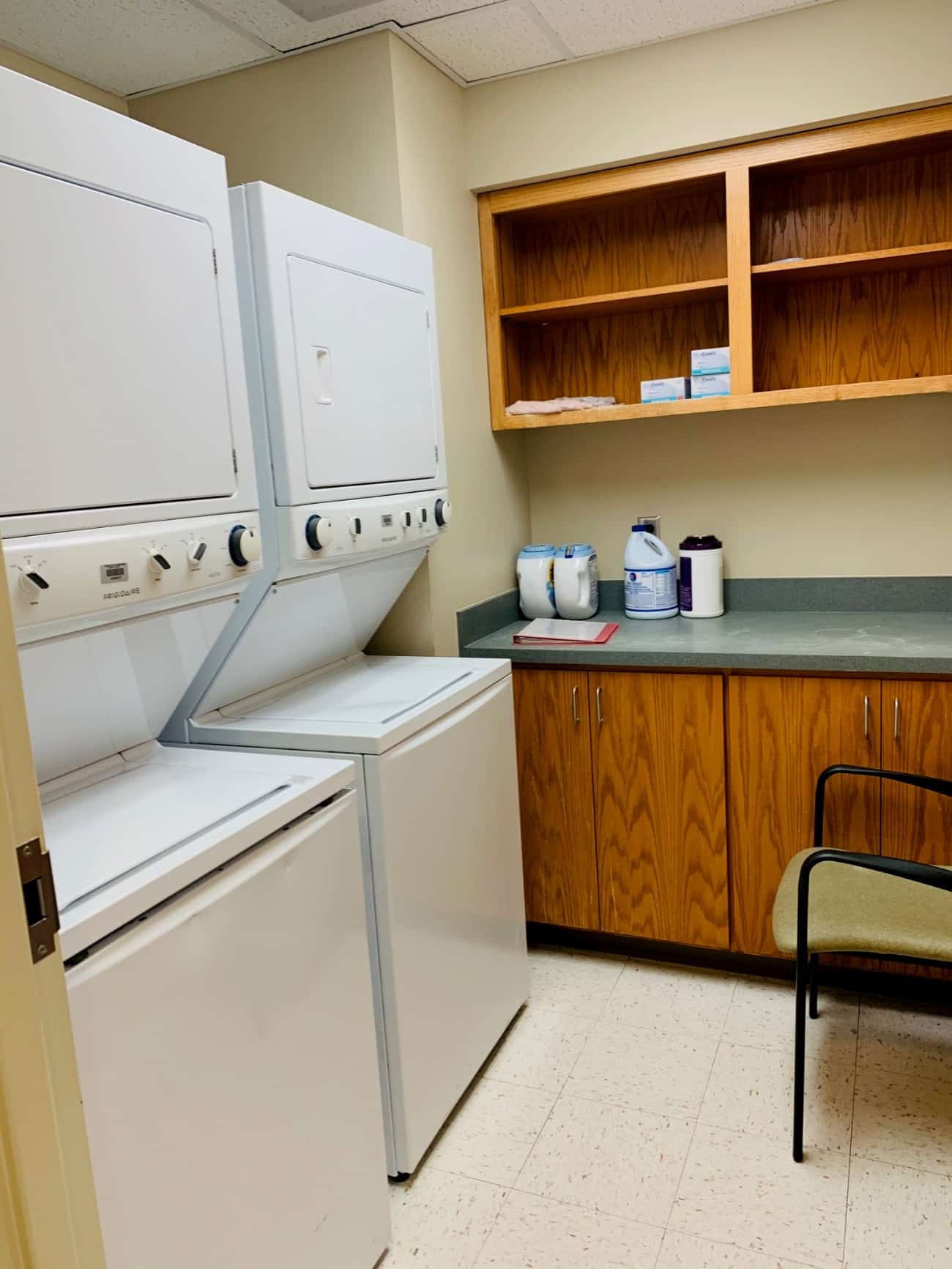 Two washer/dryer combinations stand alongside open cabinets and cupboards.