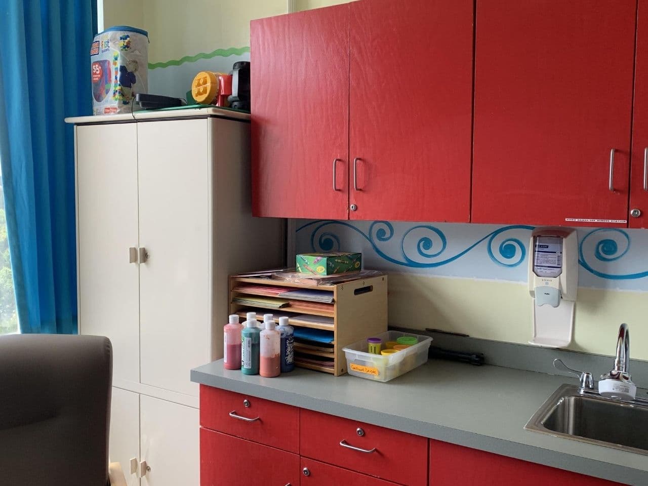 Bright red cabinets are used in the kitchen area