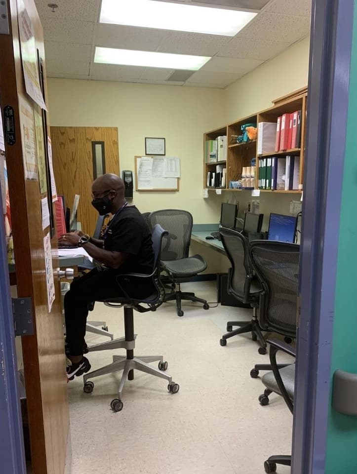 The doctor's dictation room has multiple computer stations and chairs with shelving and notebooks.