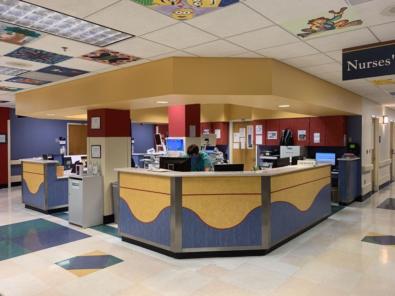 The nurses station is bright and cheery with colorful designs in the ceiling.