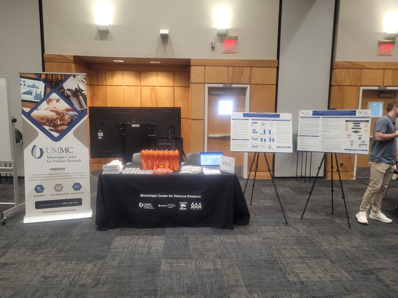 Display sign and exhibit table next to posters mounted on easels..