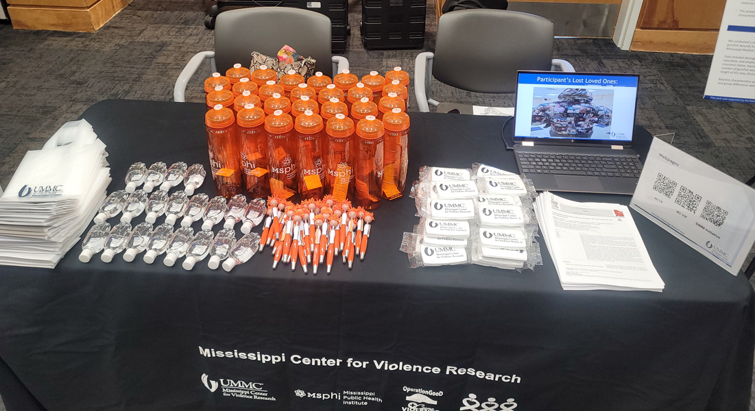 Exhibit table setup with goodie bags, water bottles and handouts.