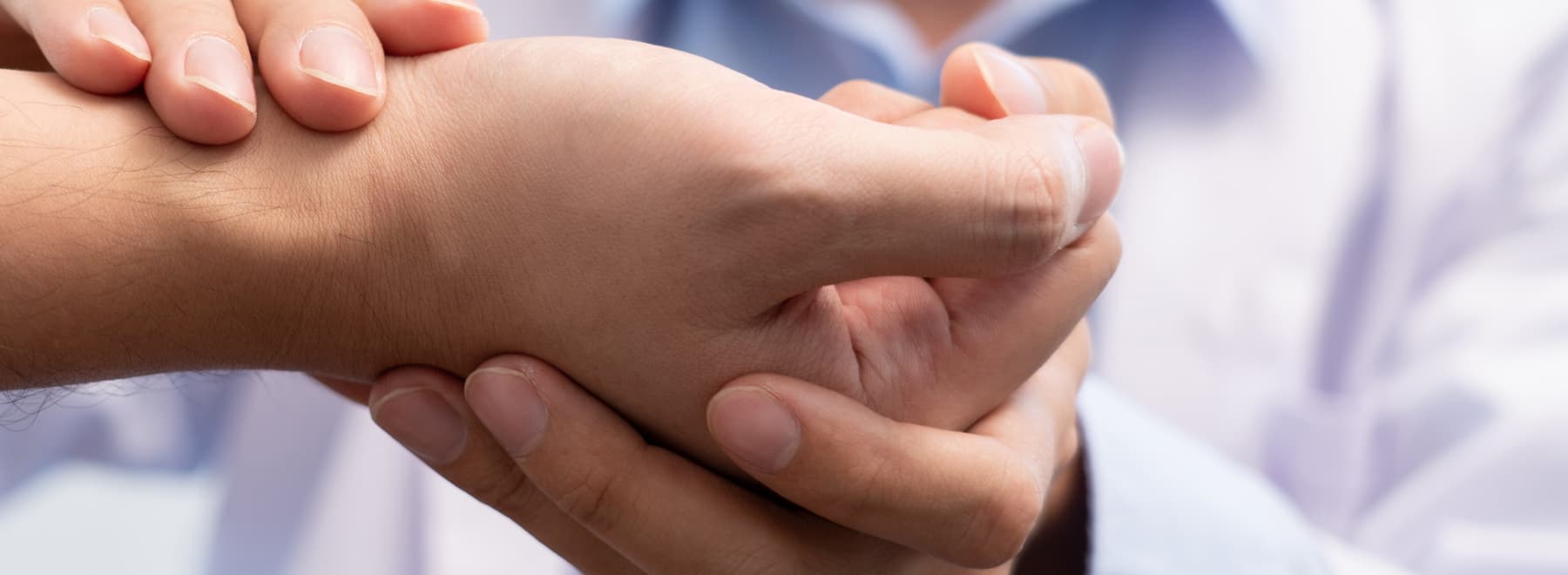 A closeup shot of a physician examining a patient's hand. A closeup shot of a physician examining a patient's hand.