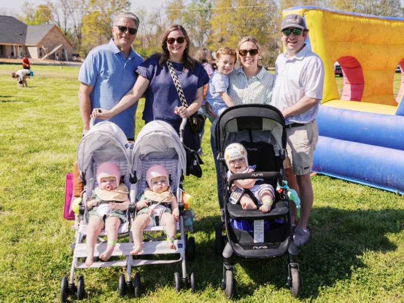 A family, including three toddlers in strollers, attend Family Fun Day 2026.