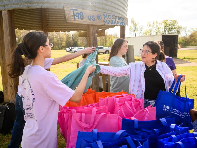 A girl picks up her t-shirt during registration at Family Fun Day 2026.
