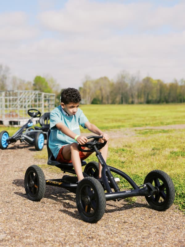 A boy rides a pedal go-kart at Family Fun Day 2026.
