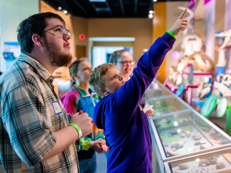 A boy points out a display feature to his dad during Family Fun Day