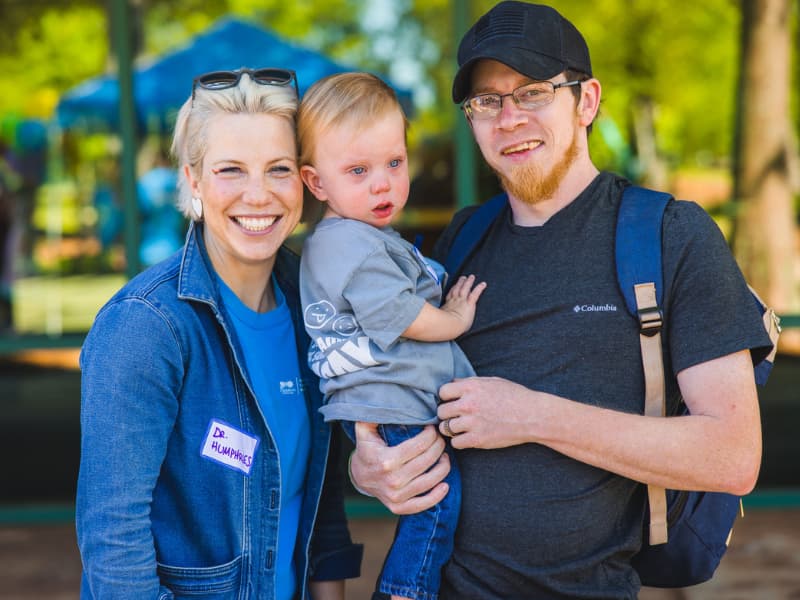Dr. Laura Humphries visits with a family at Family Fun Day