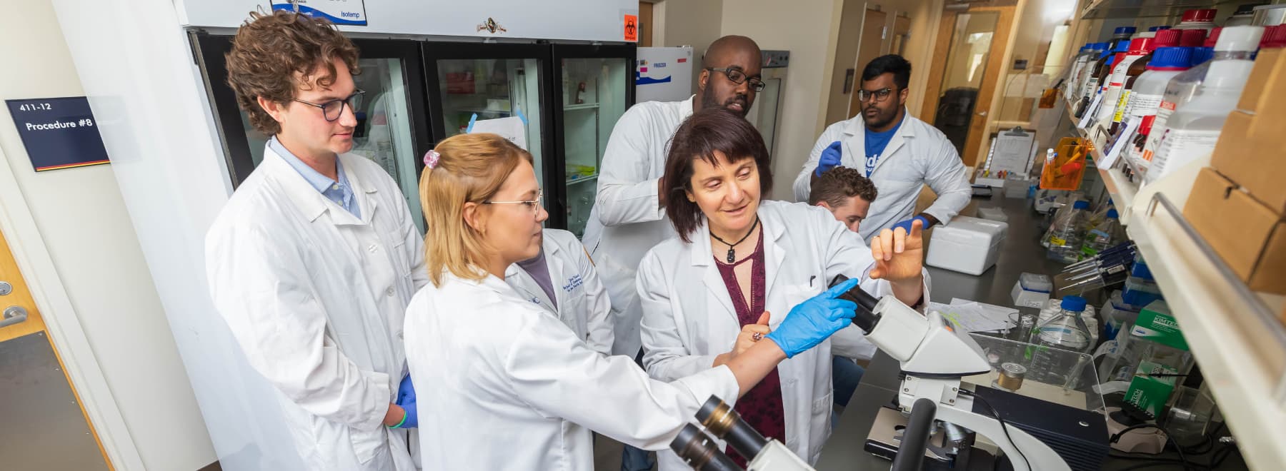 Group in lab with microscope.