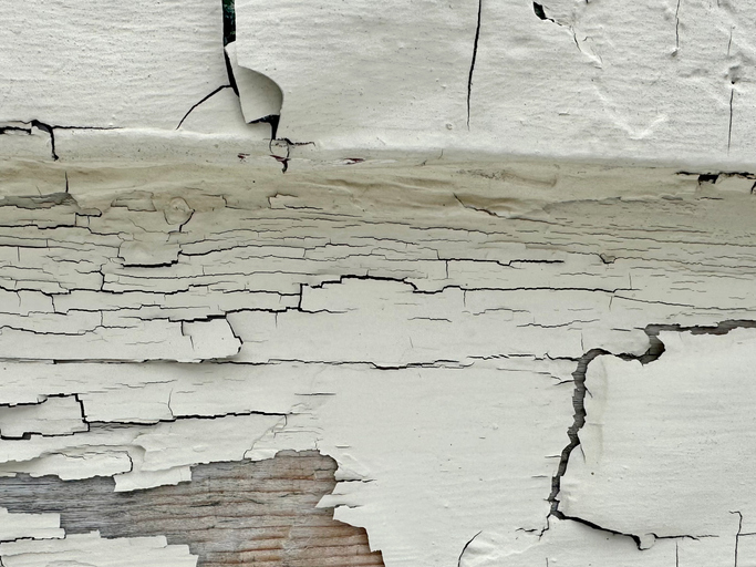 Flaking lead-based paint on wooden siding.