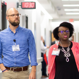 Male and female talk while touring clinical trials research unit