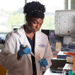 Female researcher conducts an experiment in the lab.