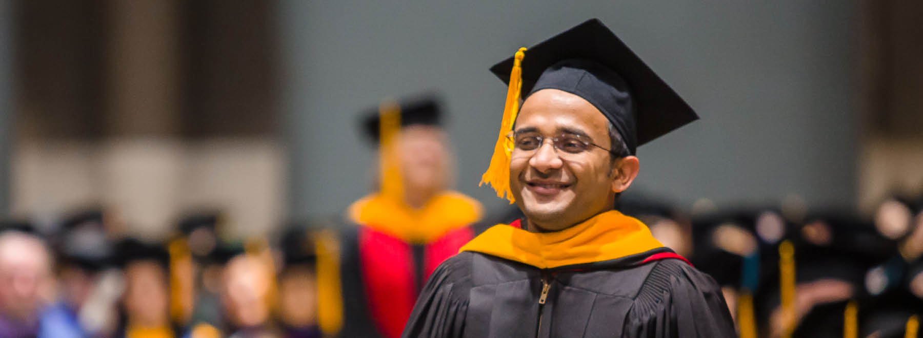 A young man in a cap and gown.