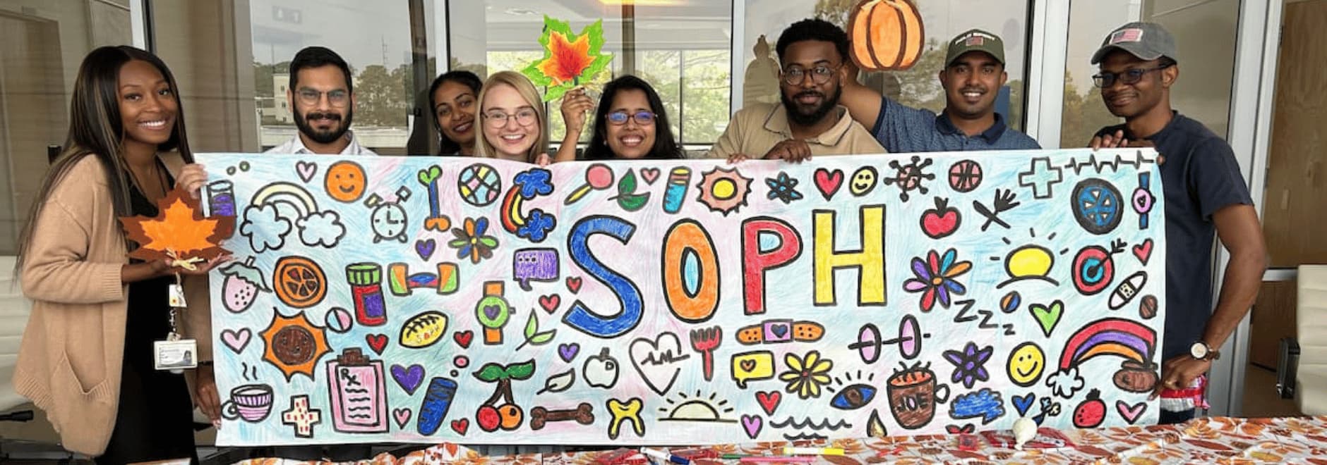 Photo of a group of SOPH students holding a banner they colored