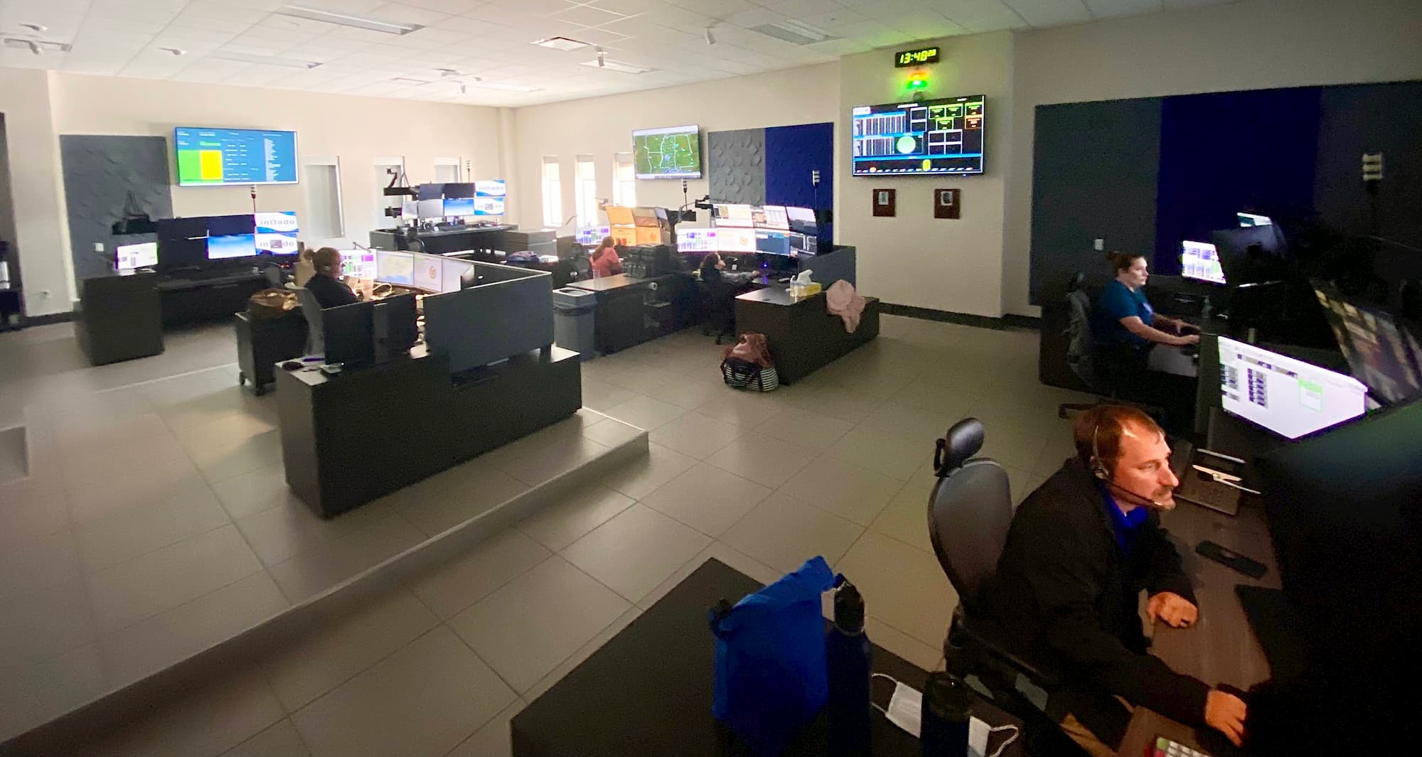 Mississippi MED-COM transfer center interior with people at desks wearing headsets.