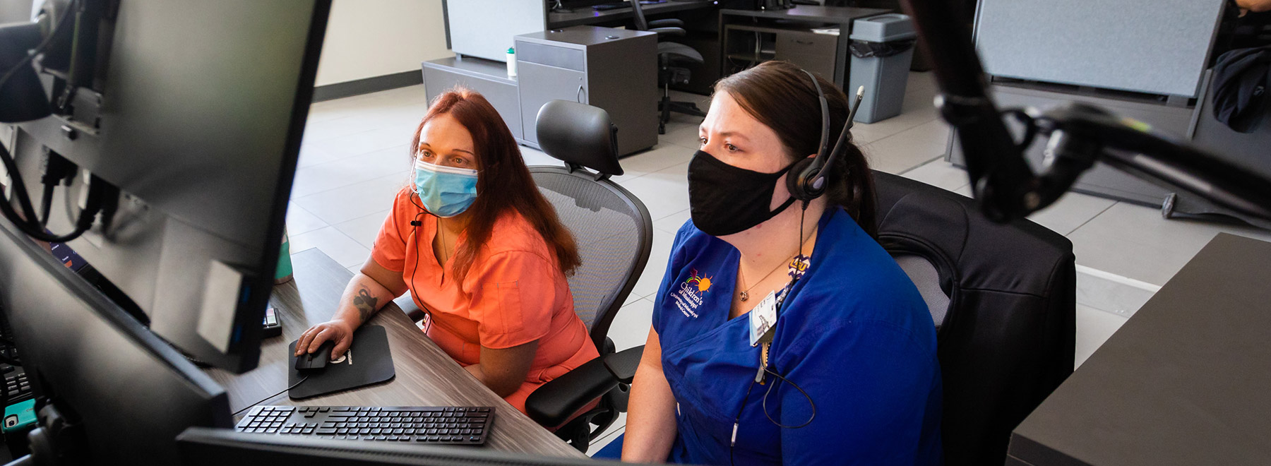 two MEDCOM staff members sitting at workstation