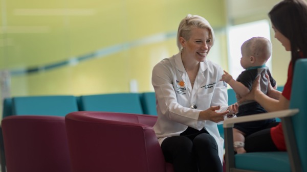 Smiling Doctor reaches out to baby.