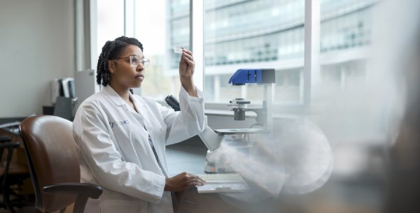 Researcher examines slide.