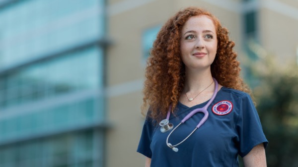 UMMC Nurse stands in front of the School of Nursing in Jackson, MS.