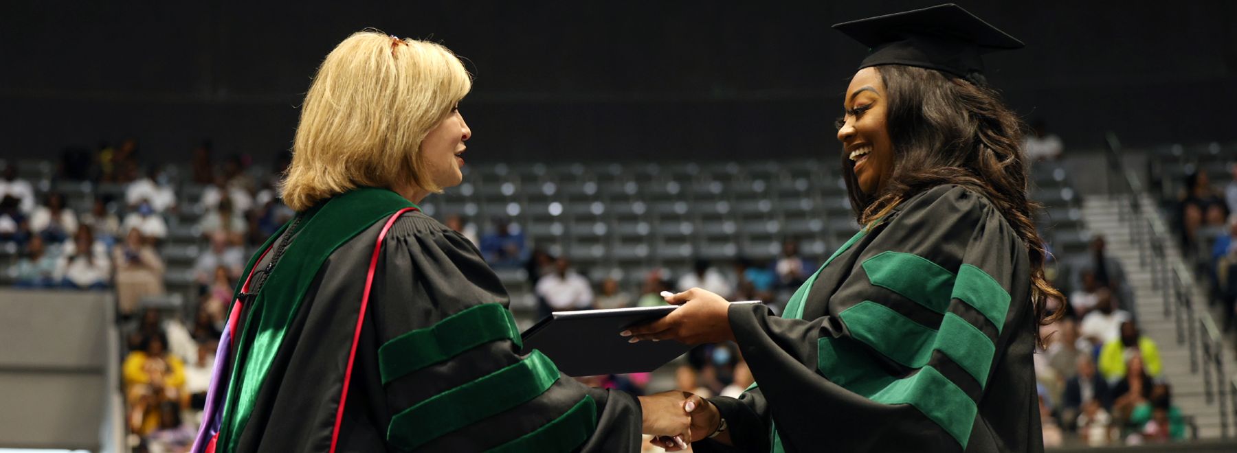 Dr. LouAnn Woodward, vice chancellor for health affairs and dean of the School of Medicine, confers degrees to students at graduation.
