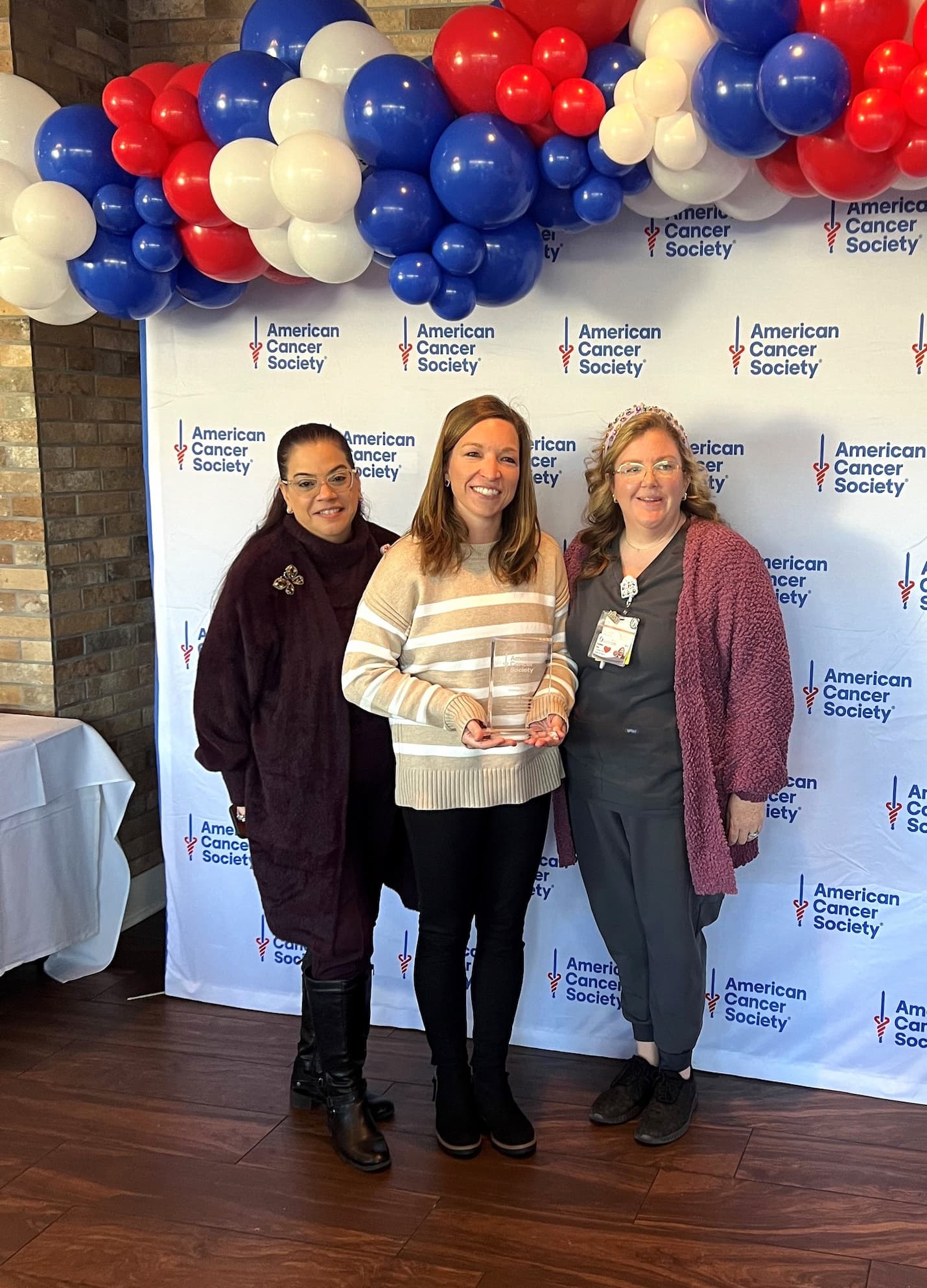 Marlene Rios, project manager III, Bethany Sabins, nurse practitioner in the Division of Gynecologic Oncology and Katie Bass, social worker proudly holds the 2024 Outstanding Health System Partner award.