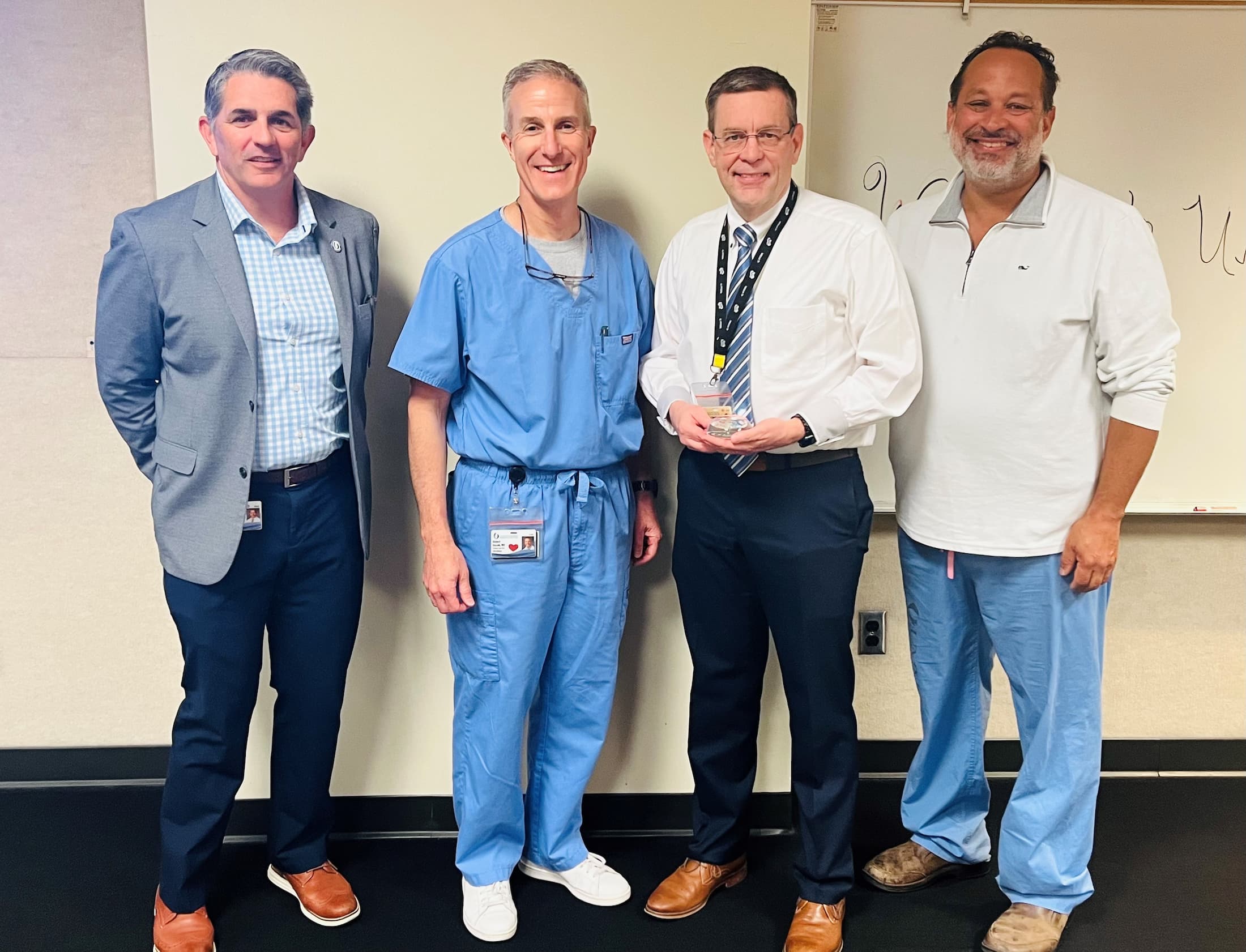 Dr. Anson Thaggard proudly receives the Employee of the Month award. Pictured, from left, is Dr. Rodney Rocconi, Dr. Richard Duszak, Dr. Anson Thaggard and Dr. Pierre de Delva.