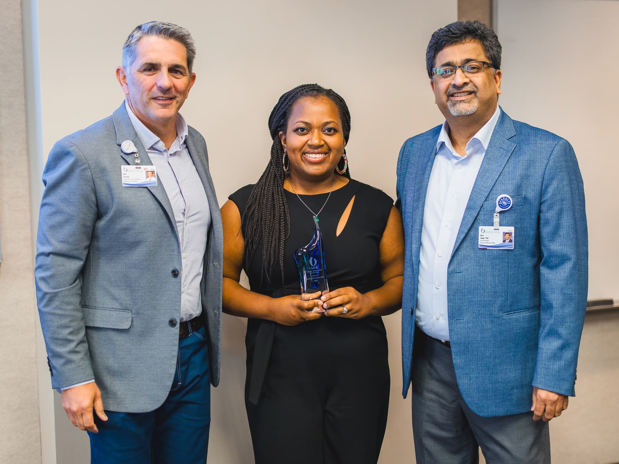 Dr. Jasmine Miller-Kleinhenz is congratulated by Dr. Rod Rocconi, left, Ergon Chair for Cancer Research and director of the Cancer Center and Research Institute, and Dr. Ajay Singh, professor of cell and molecular biology and associate director of basic and translational research at CCRI.
