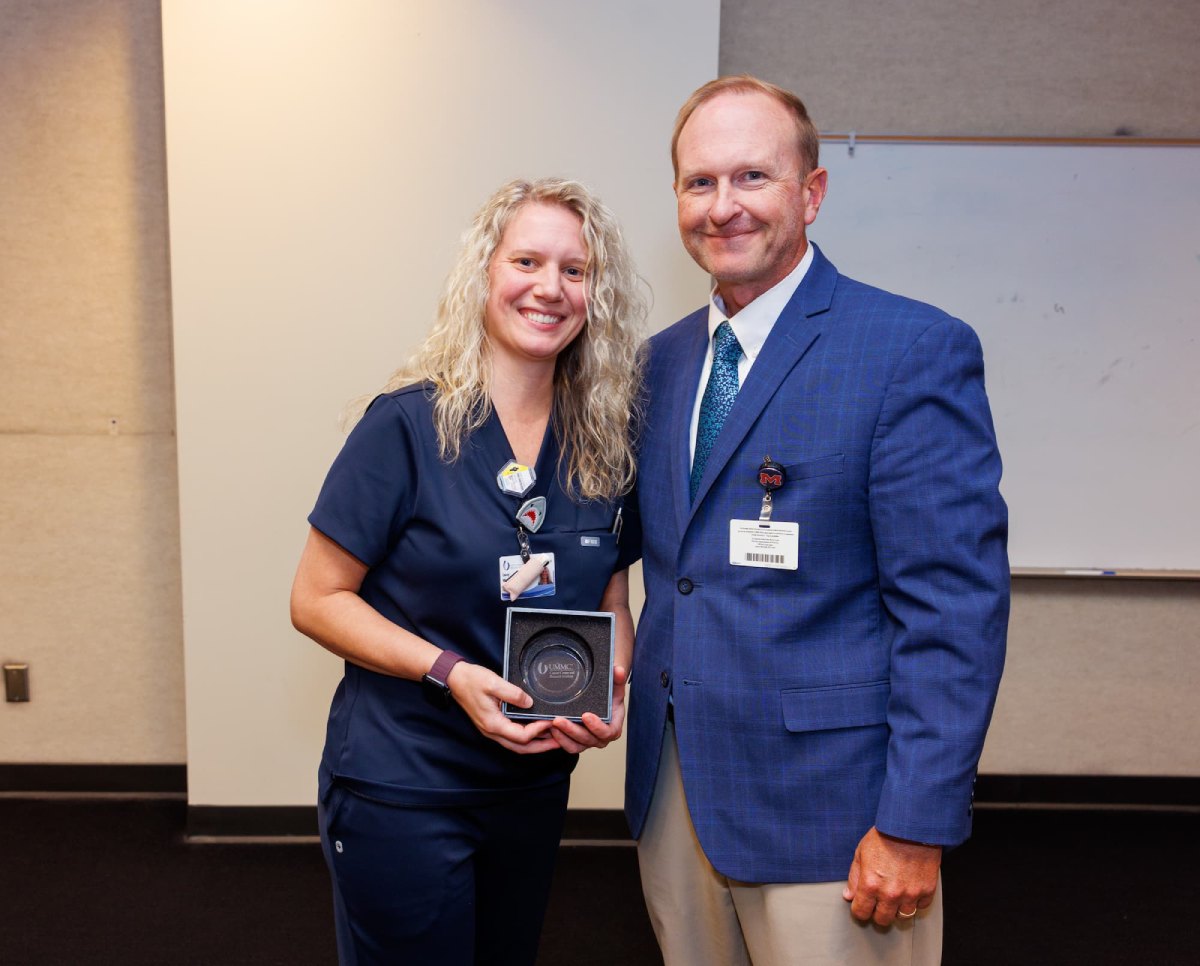 Lacey Weatherall is congratulated by Trey Woods, executive administrator of the Department of Radiation Oncology.