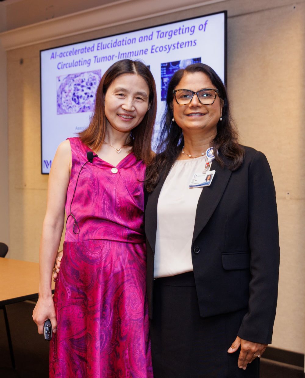 Dr. Huiping Liu, left, is greeted by Dr. Seema Singh, CCRI associate director of education and training.