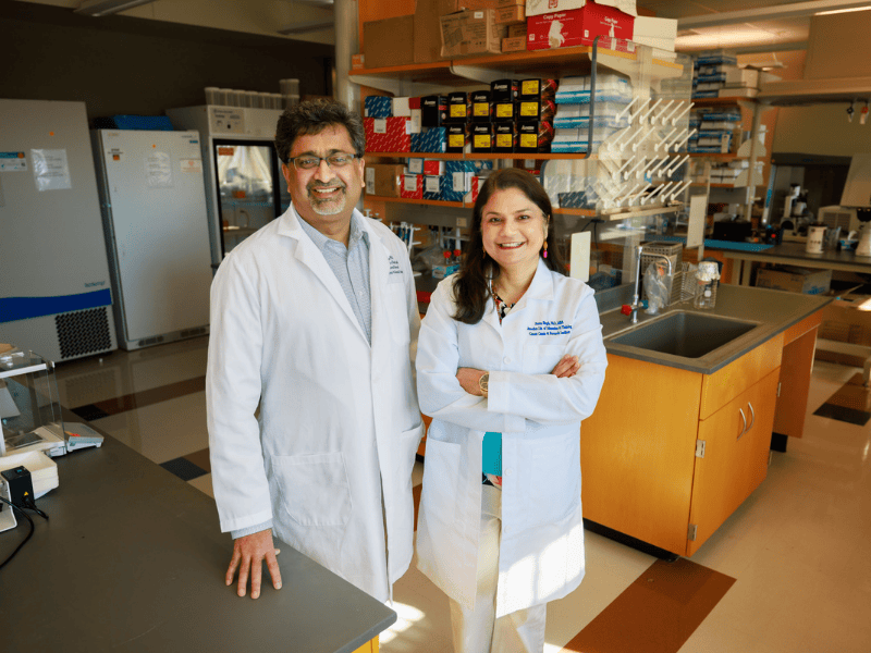 Two providers smile while posing for photo in lab.