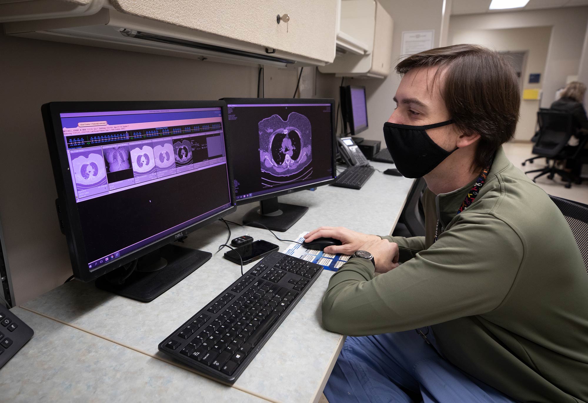 Jonathan Hontzas, a nurse practitioner and director of UMMC's lung cancer early detection program, examines scans of Johnnie Mitchell's lungs.