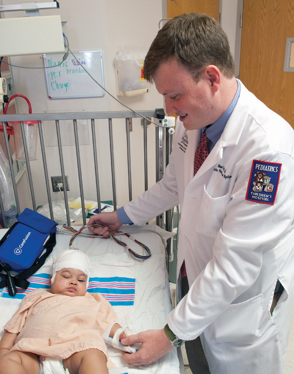 Dr. Brad Ingram, assistant professor of pediatric neurology, examines epilepsy patient Olivia Edwards.