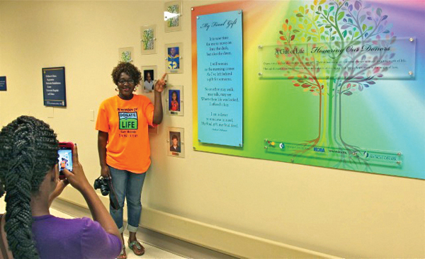 Jackie McInnis of Mount Olive has her photo taken next to the newly dedicated Wall of Heroes at Batson Children’s Hospital, which honors pediatric organ donors including her son, Gary Lenzie McInnis.