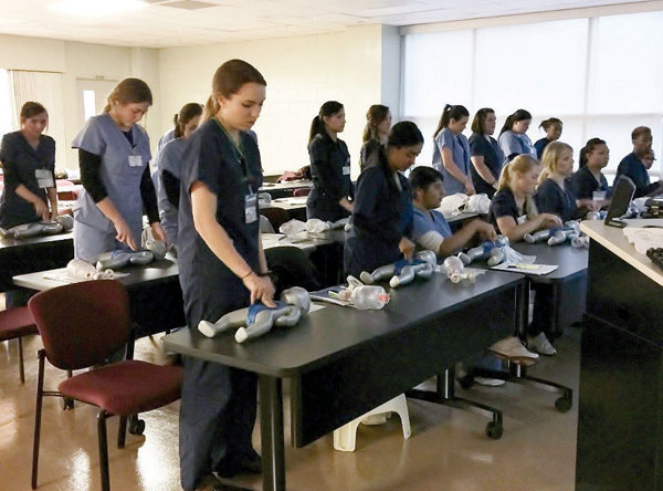 Dental hygiene students practice their CPR skills.