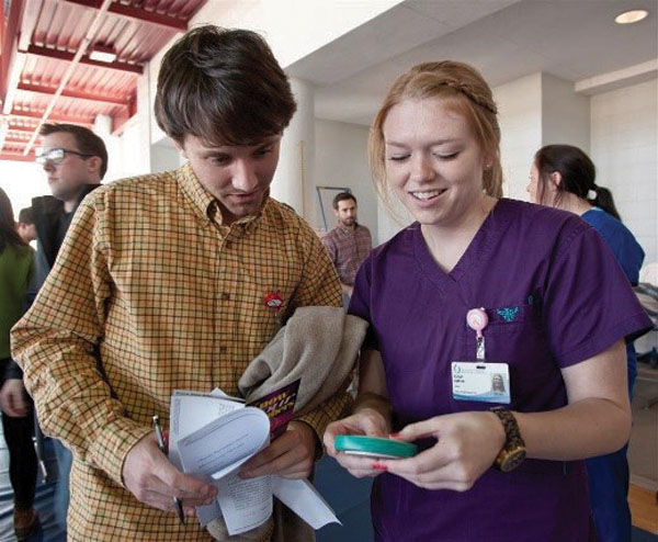 OT student Ashley Harlan, right, teaches medical student Alex Hampton how to read a BMI.