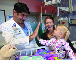 As mom Michelle Morgan of Biloxi watches, 2-year-old Abigail Morgan gives her heart surgeon, Dr. Ali Dodge-Khatami, a high five just three days after he repaired a "hole" in her heart and her leaking mitral valve in an innovative procedure performed at only a few medical centers internationally.