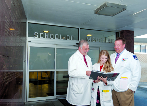 Searching through a medical school yearbook, Dr. Steve Case, left, dredges up some memories with Dr. Lyssa Weatherly, an internal medicine resident, and Eric McDonald, a fourth-year medical student.