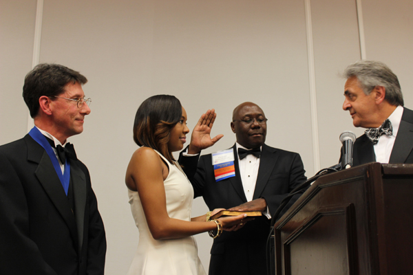 With the aid of his daughter Christin, Dr. Claude Brunson, second from right, takes the oath of office from Dr. Lee Voulters, right, chair of the MSMA Board of Trustees. Bearing witness is Dr. James Rish, left, outgoing MSMA president.