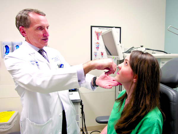 University Physicians (UP):  Dr. Scott Stringer, professor and chair of the Department of Otolaryngology and Communicative Sciences, examines Allison Pitts, a physician’s assistant who is one of his patients.