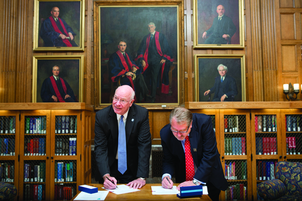 Dr. James E. Keeton, UMMC vice chancellor for health affairs and medical school dean, left, and Dr. Greg Gores, executive dean of research at the Mayo Clinic, sign a formal agreement between their two medical centers on Sept. 30 in Rochester, Minn. The pact creates a partnership between UMMC and Mayo to cooperate on matters of research, clinical trials and education.