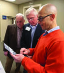 Dr. Mitch Massey, left, and Dr. Hugh Brown, center, look over a 1974 group portrait of the orthopaedic surgery residents with Dr. George Russell.