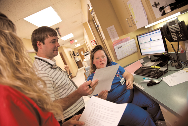 Dr. Sam Holdiness, left, consults with Kimberly Cuny, R.N. Holdiness’ father, Dr. Gary Holdiness, wrote her a recommendation for her entrance into nursing school.